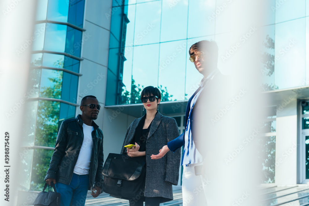 Three happy business colleagues talking outside the office Three happy business colleagues talking outside the office