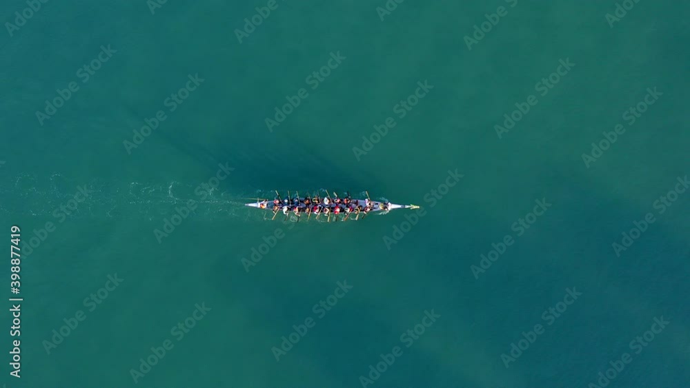 Dragon Boat team rowing to the pace of an onboard Drummer, Aerial view.
Dragon Boat team rowing to the pace of an onboard Drummer, Aerial view.