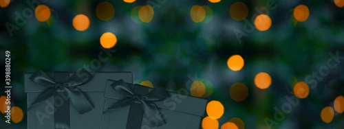 Festive decorative Christmas  birthday background banner panorama - Dark green blue gift boxes   presents with ribbon isolated on dark green blue background with yellow orange bokeh lights