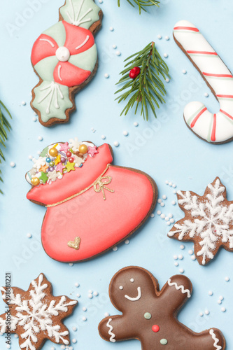 Beautiflly decorated gingerbread cookies on wintery blue background. Tasty homemade Christmas cookies close up view. 
 photo