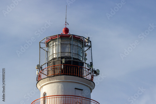 A view of the top part of the black and white striped with red painted steel balcony Daugavgriva (Bolderaja) lighthouse in Riga, Latvia, set on the shore where Bay of Riga and Daugava River meets. photo