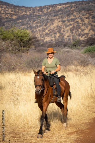 Blonde horsewoman in savannah rides towards camera © Nick Dale