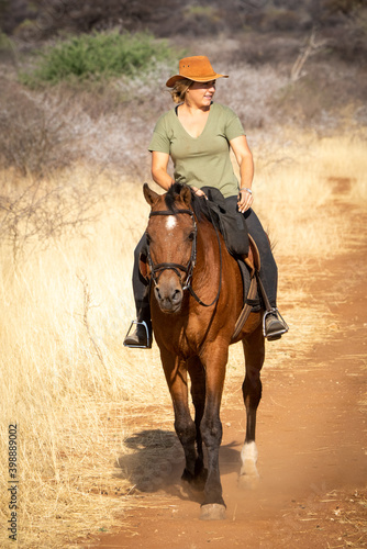 Blonde horsewoman rides looking right in savannah © Nick Dale