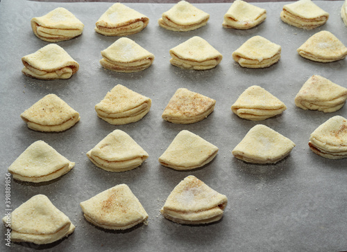 Homemade cakes on a baking sheet. homemade cookies in the form of triangles before baking.