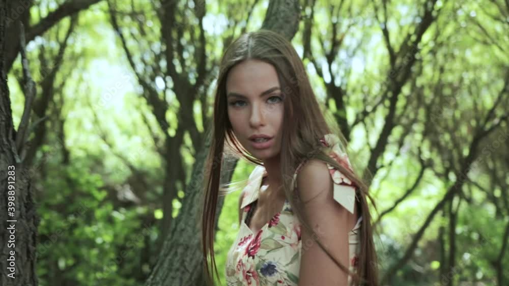 Beautiful girl in a summer dress walking through a pine forest, slow motion Beautiful girl in a summer dress walking through a pine forest, slow motion