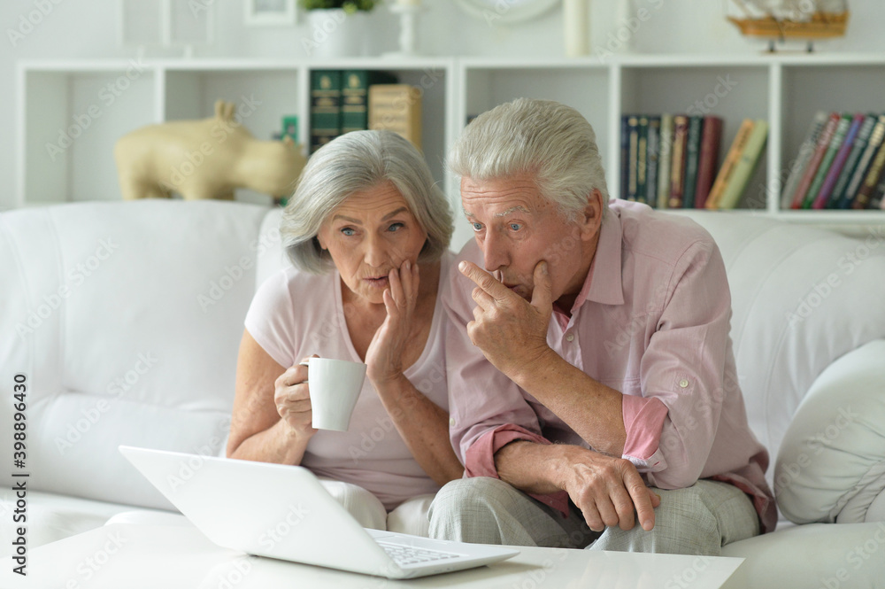 Surprised senior couple with laptop at home Surprised senior couple with laptop at home