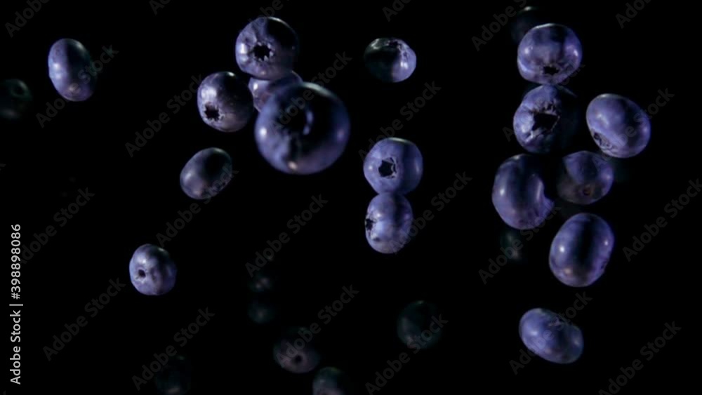 Juicy mouthwatering blueberries are bouncing up on the black background in slow motion Juicy mouthwatering blueberries are bouncing up on the black background in slow motion