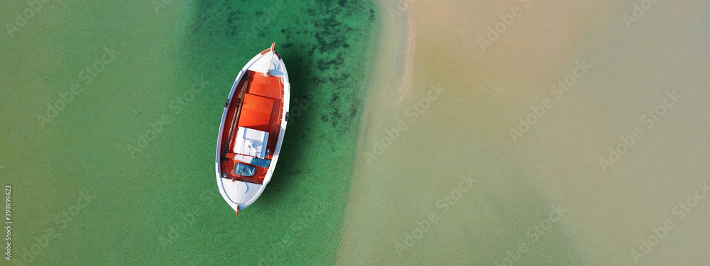 Aerial drone top view ultra wide panoramic photo of traditional wooden fishing boat anchored in crystal clear turquoise sea of Antipaxos island, Ionian sea, Greece Aerial drone top view ultra wide panoramic photo of traditional wooden fishing boat anchored in crystal clear turquoise sea of Antipaxos island, Ionian sea, Greece