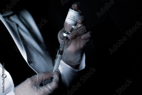 Doctor laborant scientist preparing covid 19 coronavirus vaccine to injector