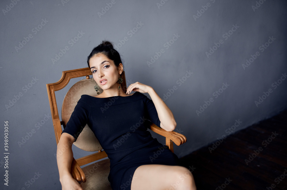 elegant lady sitting on a chair indoors evening dress hairstyle makeup model