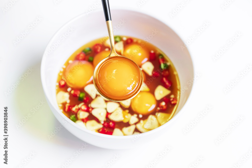Pickled eggs yolk in fish sauce with chili pepper and garlic sliced in
