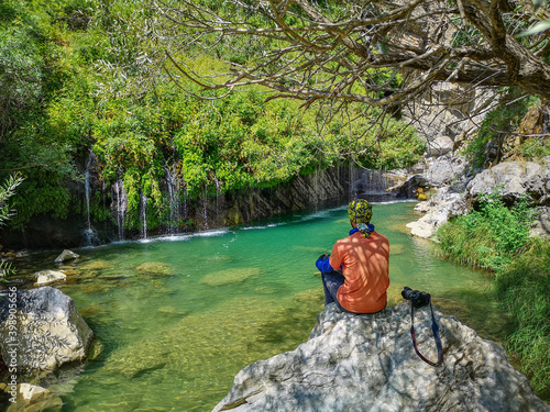 waterfall flowing in nature, a man sitting on a stone, a waterfall, a waterfall among the rocks. Hakkari in Turkey
