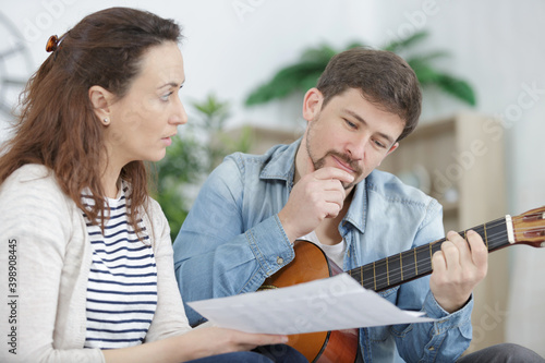man playing guitar with a friend