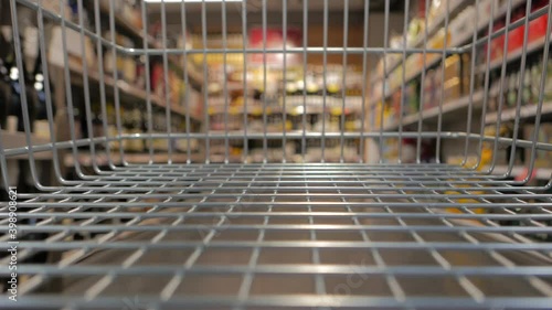 Inside a supermarket cart shopping groceries (featuring alcohol shelves)
