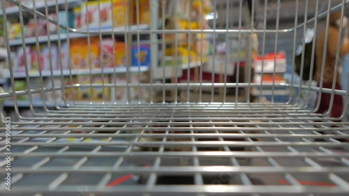 Inside a supermarket cart shopping groceries (featuring a baby stroller)

