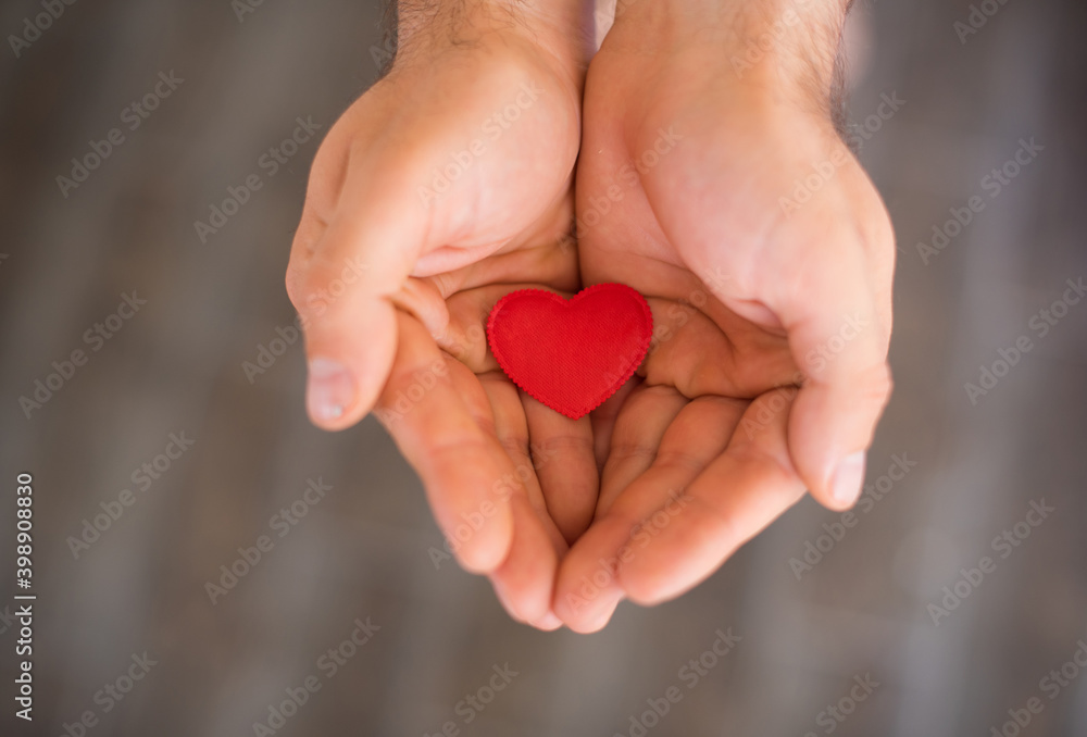 Top view of decorative red heart in man hands ,Valentines day concept, romantic concept, world health day concept.Love Top view of decorative red heart in man hands ,Valentines day concept, romantic concept, world health day concept.Love