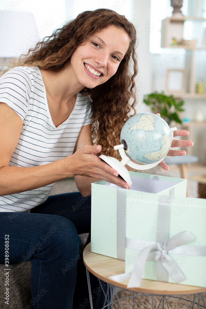 young beautiful woman opening gift bow with globe young beautiful woman opening gift bow with globe