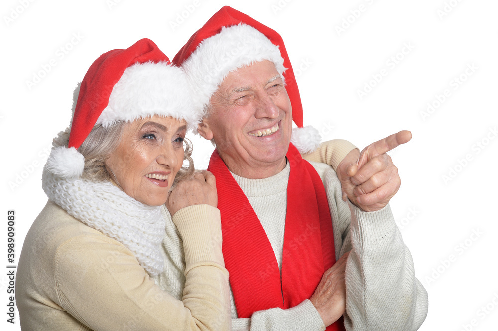 Portrait of happy senior couple in Santa hats pointing Portrait of happy senior couple in Santa hats pointing