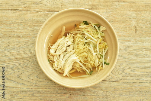 chinese yellow egg noodles topping slice boiled chicken in soup on bowl