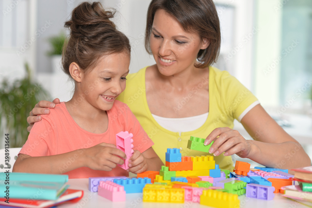 Girl and her mother playing with blocks at home