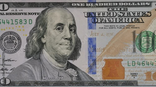 Ben Franklin winks at us from the 100 dollar bill. Funny character animation of the United States money. photo