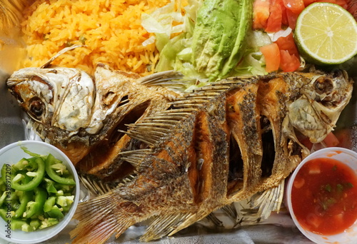 Pescado Frito, Mexican dish with fried tilapia, yellow rice and salad