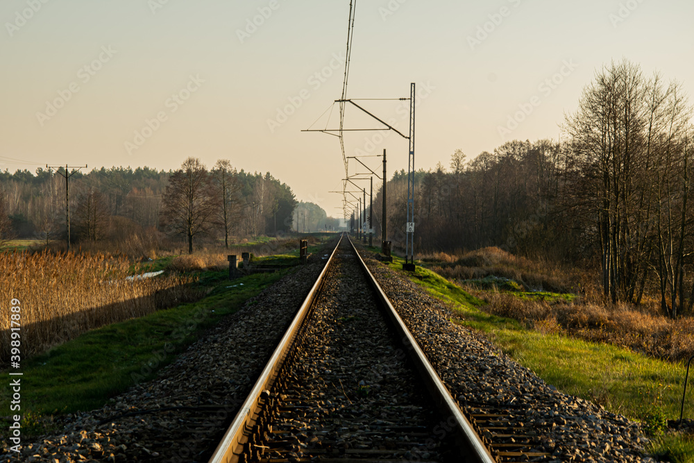 An railway track with a single track leading through meadows and forests An railway track with a single track leading through meadows and forests