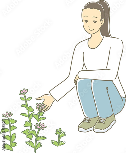 Woman crouching down and staring at flowers.