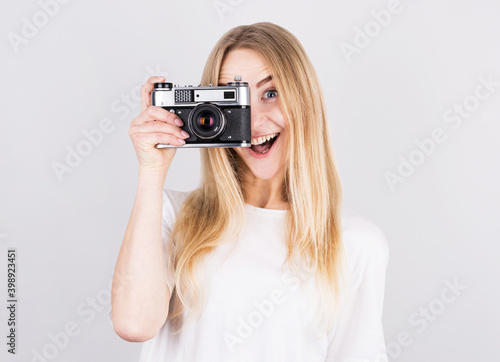 Happy smiling young girl holding camera and taking photos © MP Studio