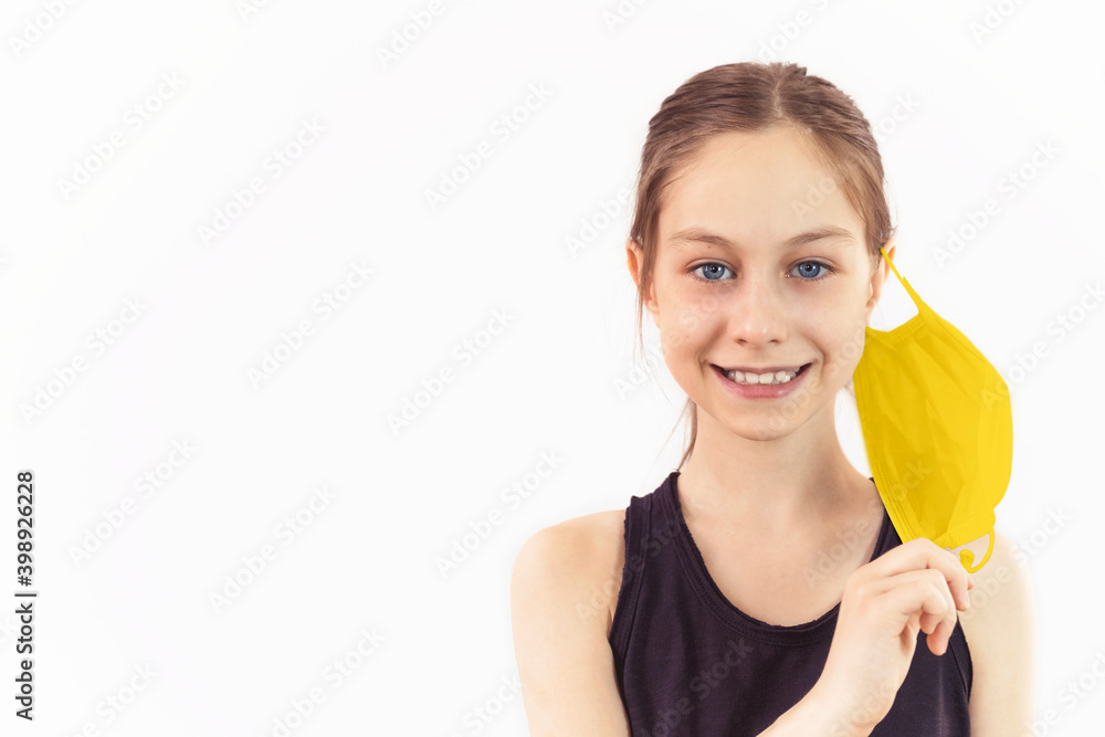 Teenage girl on white background smiling and taking off protective mask Teenage girl on white background smiling and taking off protective mask