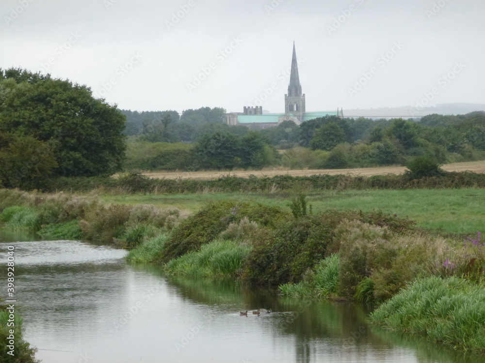 The canal, vegetation and the cathedral in the distance