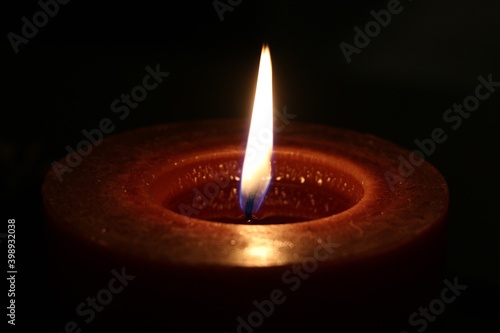 Red burning candle in the dark