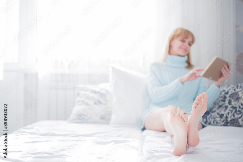woman is relaxing on comfortable couch and using tablet at home woman is relaxing on comfortable couch and using tablet at home