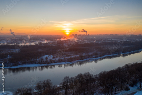 panoramic view of the park in the city on the river bank with old buildings at sunrise in winter filmed from a drone © константин константи