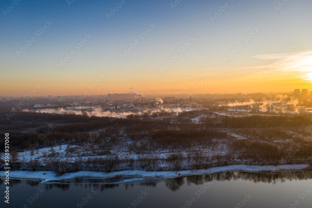 panoramic view of the park in the city on the river bank with old buildings at sunrise in winter filmed from a drone