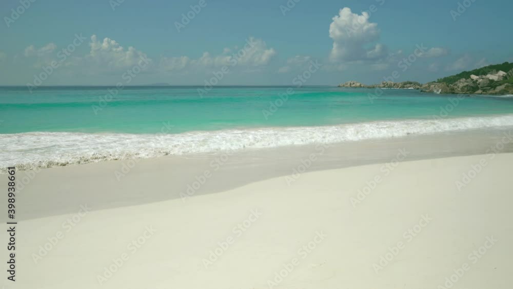 Exotic beach by the ocean with rolling waves on the sandy shore and blue sky. Exotic beach by the ocean with rolling waves on the sandy shore and blue sky.