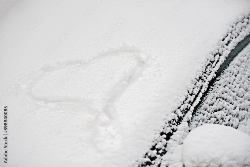 Fototapeta premium snowy heart on the windshield of a car, winter photo