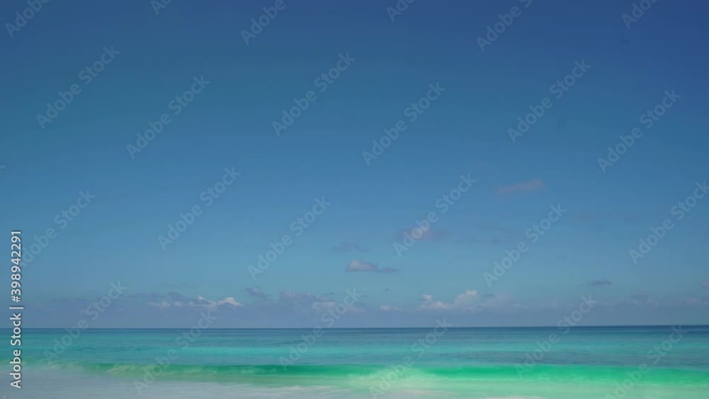 Exotic beach by the ocean with rolling waves on the sandy shore and blue sky. Exotic beach by the ocean with rolling waves on the sandy shore and blue sky.