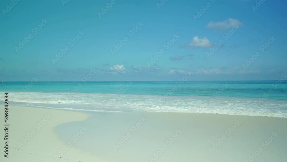 Exotic beach by the ocean with rolling waves on the sandy shore and blue sky. Exotic beach by the ocean with rolling waves on the sandy shore and blue sky.
