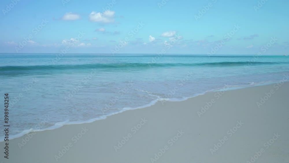 Exotic beach by the ocean with rolling waves on the sandy shore and blue sky. Exotic beach by the ocean with rolling waves on the sandy shore and blue sky.