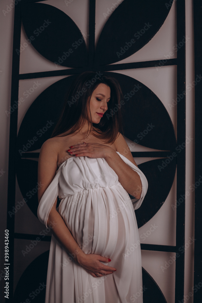 Fototapeta premium Красивая беременная девушка в белом платье