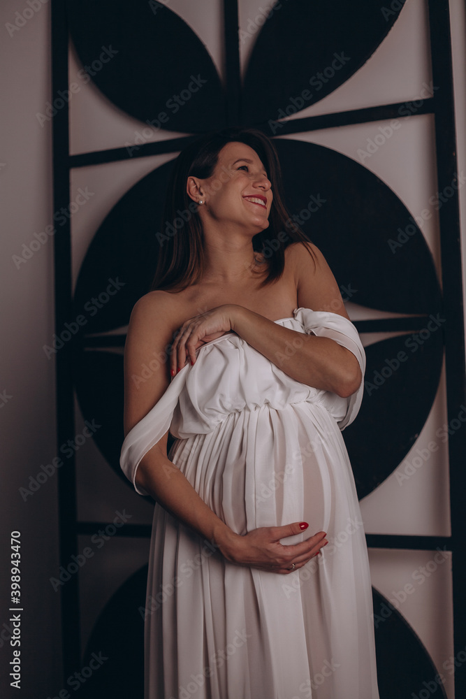 Красивая беременная девушка в белом платье
