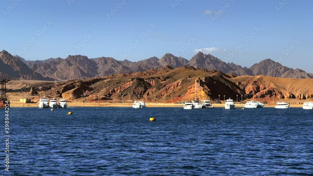 Yachts, Harbor and mountains in background sea coast. Amazing summer travel vacation beach background. Nature background. Amazing with blue mountains sea yachts. Nature blue sky, seascape Yachts, Harbor and mountains in background sea coast. Amazing summer travel vacation beach background. Nature background. Amazing with blue mountains sea yachts. Nature blue sky, seascape