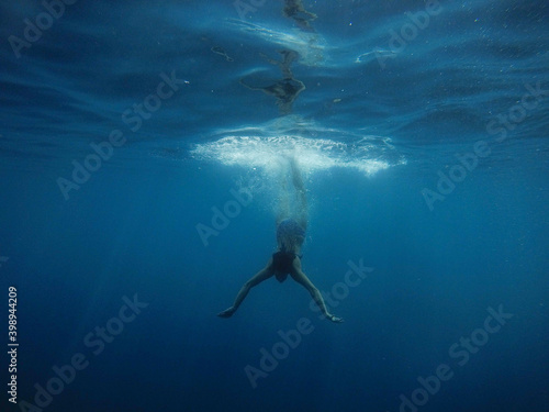 girl dives into the blue water