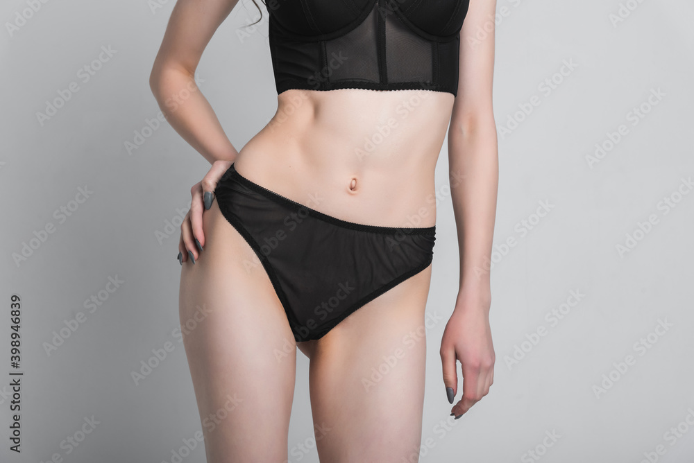 Beautiful, slender female figure in a bikini on a gray background. The concept of fashion photography and clothing Beautiful, slender female figure in a bikini on a gray background. The concept of fashion photography and clothing