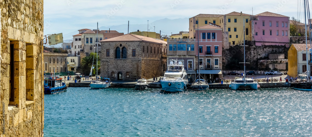 Colourful houses line the quayside in Chania harbour, Crete on a bright sunny day