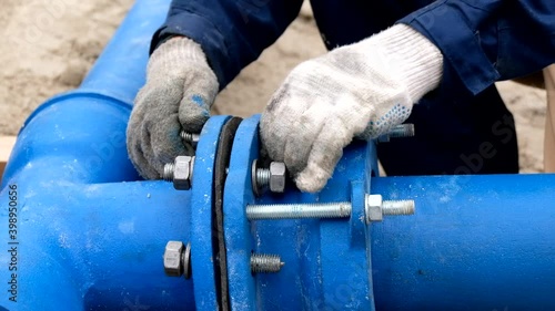 Workers installing water supply pipeline system, close up