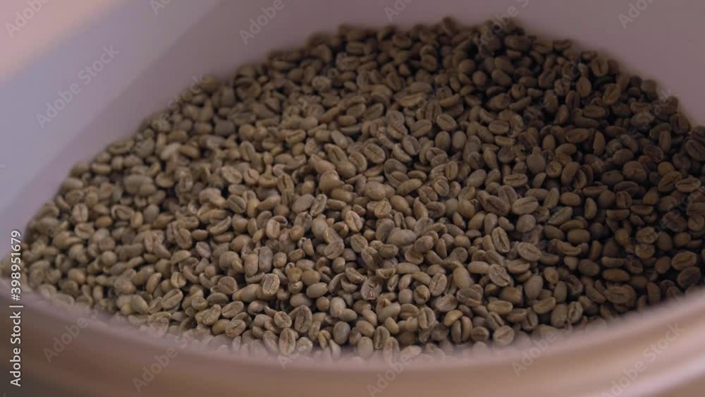Pouring green coffee beans for measuring Pouring green coffee beans for measuring