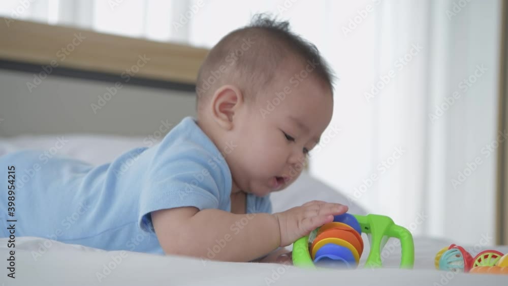 Family concept of 4k Resolution. The baby is lying alone playing with toys on the bed. Family concept of 4k Resolution. The baby is lying alone playing with toys on the bed.