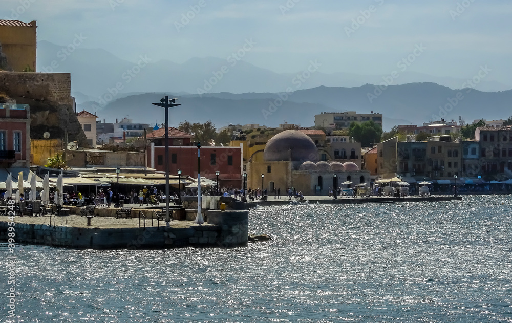A view of Chania harbour, Crete with the White Mountains in the distant haze on a bright sunny day
